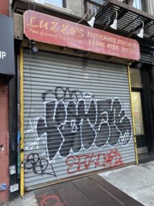 closed restaurant with graffiti on gate