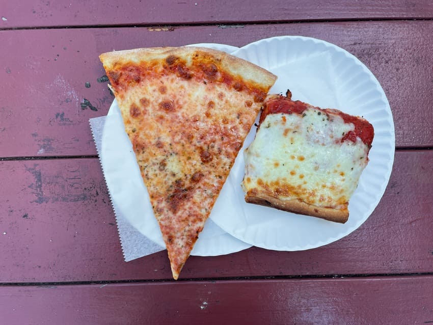 two slices of pizza on two paper places, one is a Sicilian edge and the other is a classic slice