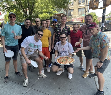 a group of men worshipping a pizza in honor of a pending wedding