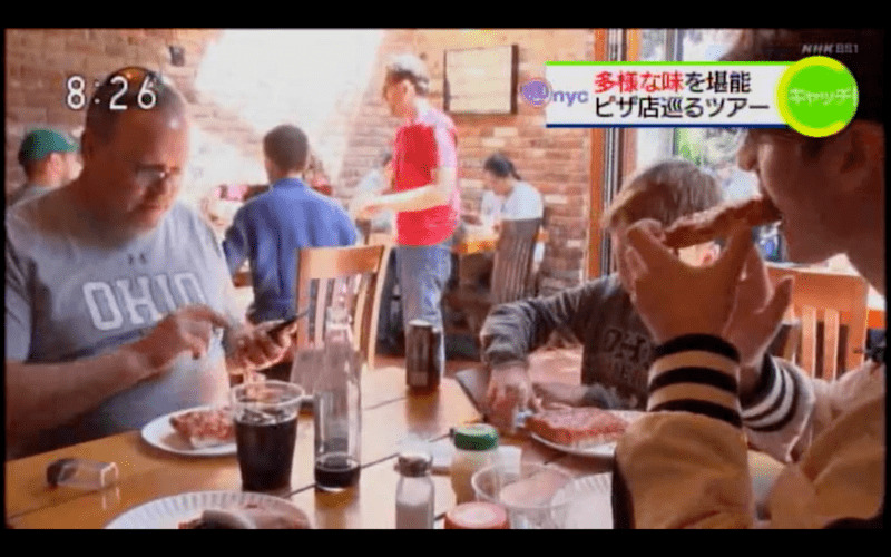 a family eats pizza while on a pizza tour in New York City