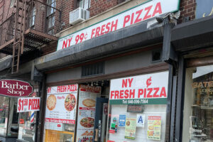 pizzeria facade showing 99 cent pizza with signage advertising $1.50 pizza