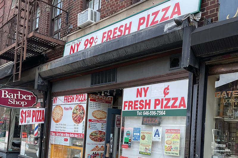 pizzeria facade showing 99 cent pizza with signage advertising $1.50 pizza