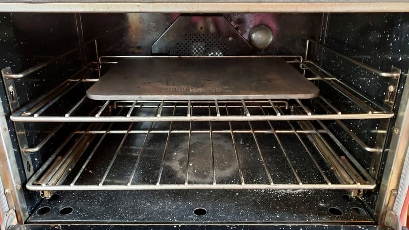 a baking steel pre-heating in a home oven