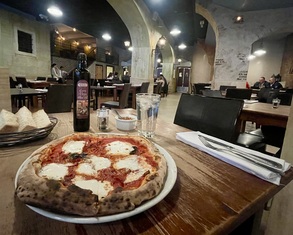 a pizza in a table inside a large restaurant